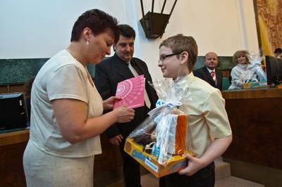 Vedoucí oddělení školství Marta Szücsová gratuluje oceněnému Vojtěchovi Kuchařovi ze základní školy A. Kučery v Ostravě Hrabůvce.