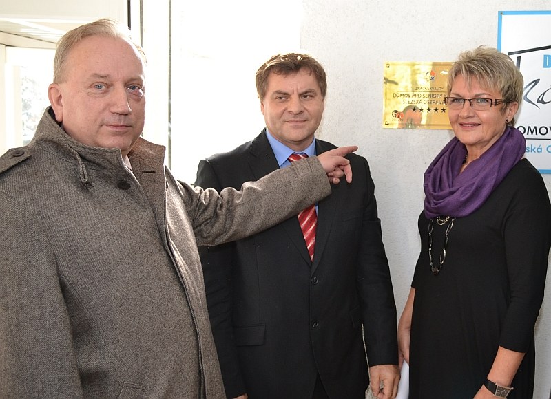 A. Maštalíř, J. Chomič a J. Rovňáková před připevněnou značkou kvality