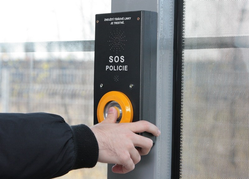 Detail SOS tlačítka. Je na něm varování: Zneužití tísňové linky je trestné.