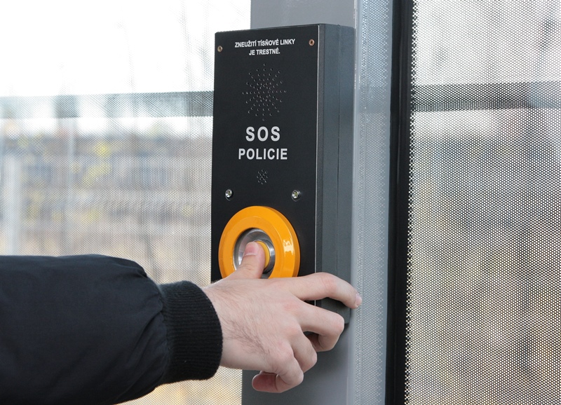 Detail SOS tlačítka. Je na něm varování: Zneužití tísňové linky je trestné.