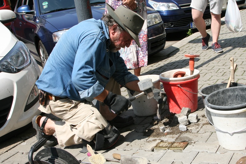 Gunter Demnig při usazování pamětních dlažebních kostek.