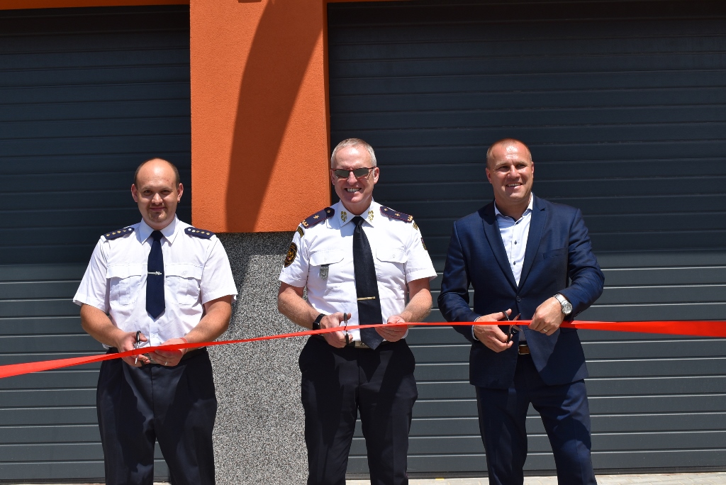 Ondřej Cága, generál Vladimír Vlček a starosta Polanky nad Odrou Pavel Bochnia stříhají pásku opravené zbrojnice. 