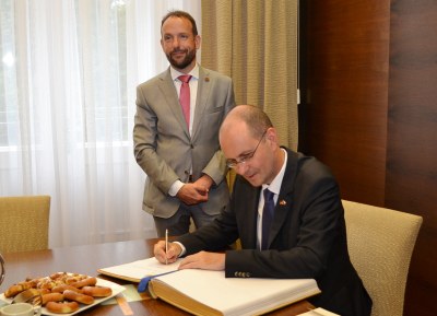 Primátor Tomáš Macura s velvyslancem Christophem Israngem, který se podepisuje do pamětní knihy Ostravy. Foto: René Stejskal 