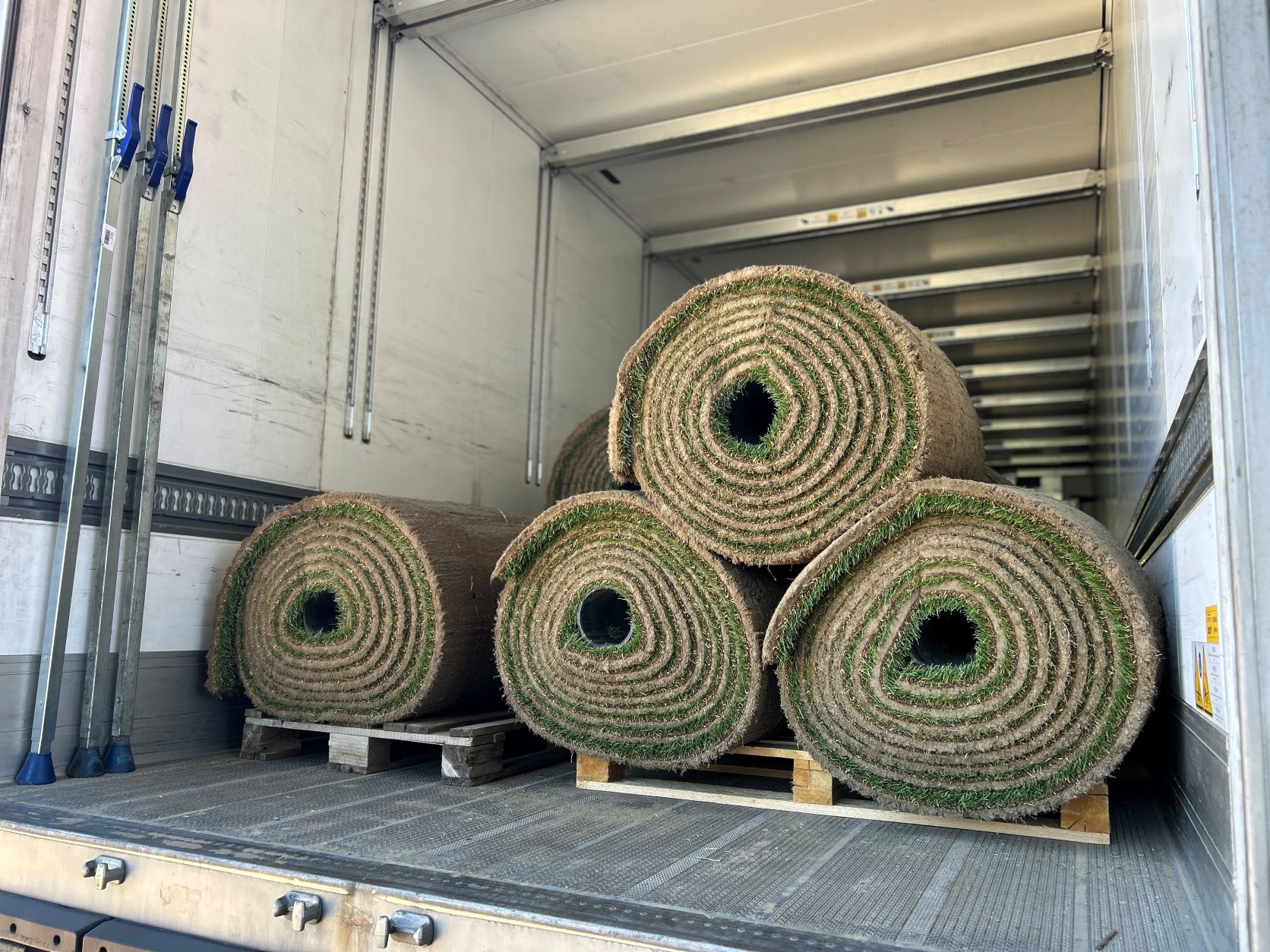 Srolovaný travnatý povrch čeká v kamionovém přívěsu na své upotřebení