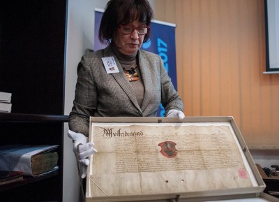 Při setkání s novináři předvedla ředitelka AMO B. Przybylová nejcennější archiválie. Na snímku listina českého krále Ferdinanda ze 7. června 1532, kterou byla povýšena na městys obec Třebovice. Foto: L. Kaboň
