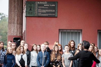 Sbor gymnázia zpívá píseň pod odhalenou pamětní deskou Rudolfu Tlapákovi. Foto: Lukáš Kaboň
