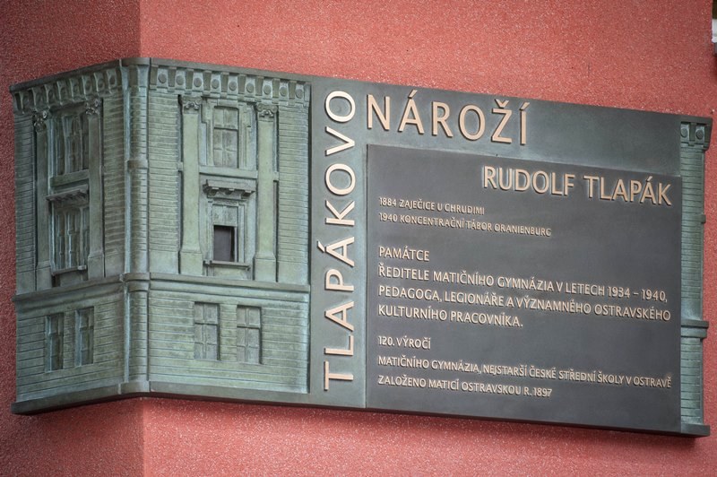 Pamětní deska Rudolfu Tlapákovi, která dává jméno nároží u školy. 