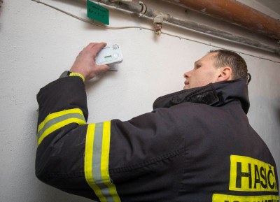 Dobrovolný hasič z Nové Vsi montuje detektor oxidu uhelnatého v obecním domě. Foto: Jiří Zerzoň