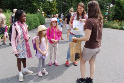 Pracovnice zoo (vpravo) předává jubilejní návštěvnici upomínkové předměty. Foto: Archiv zoo